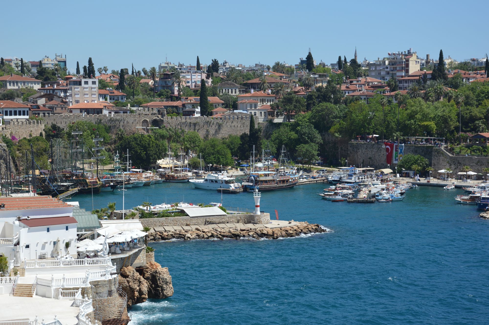 Kaleiçi harbour with boats, historic walls, red roofs, and the Mediterranean Sea